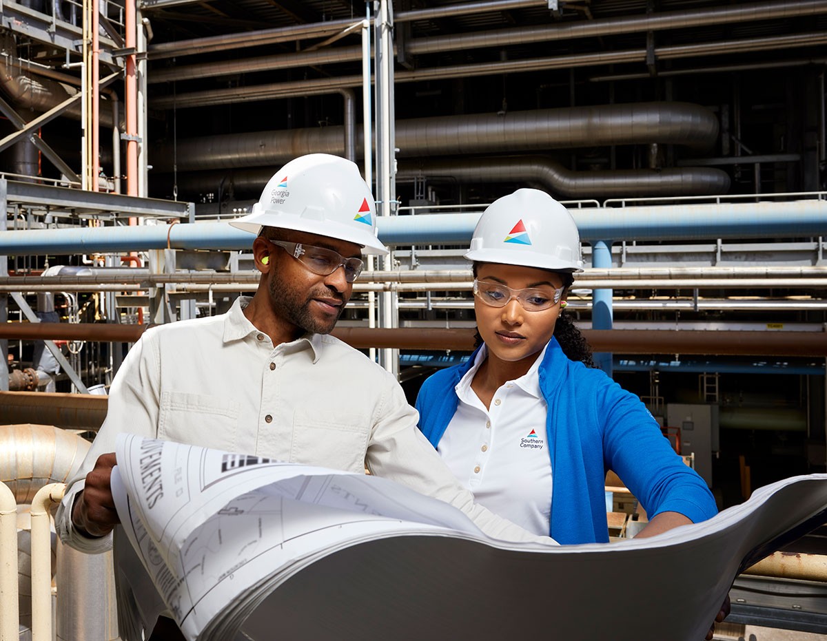 Man and a woman reviewing plans at generating facility
