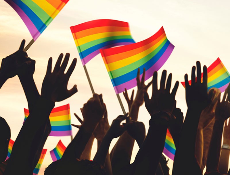 Pride flag and hands celebrating