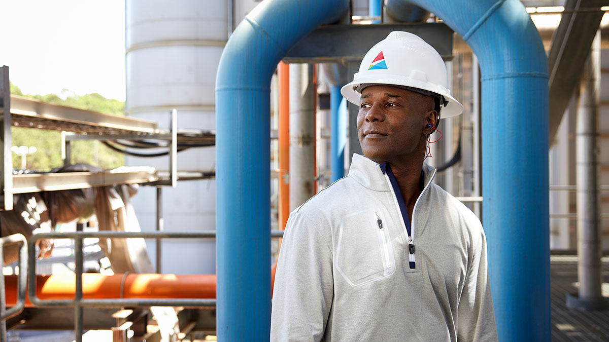 Black man wearing hardhat with Southern Company logo standing at power plant