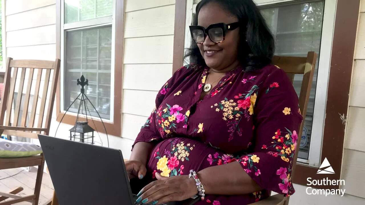 Tanisha Corporal working on a laptop on her porch