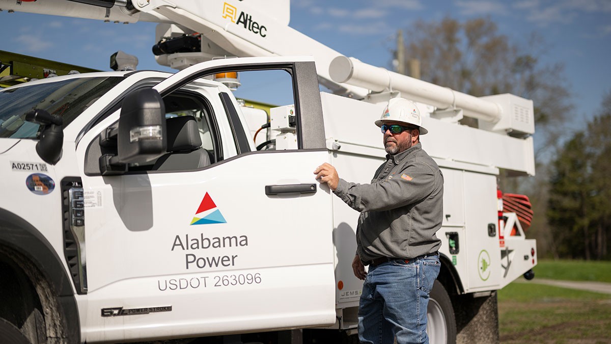 Alabama Power lineman stepping out of an Alabama Power bucket truck