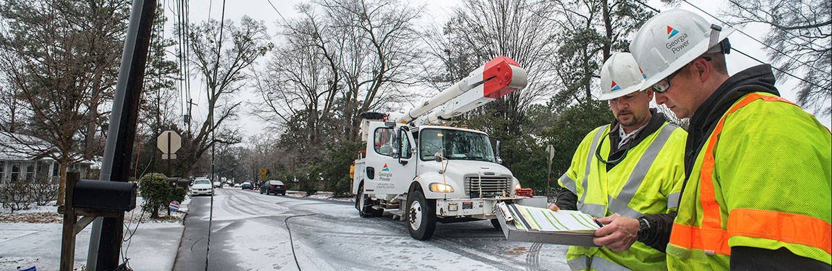 Georgia Power lineman on winter, residential street repairing downed power line