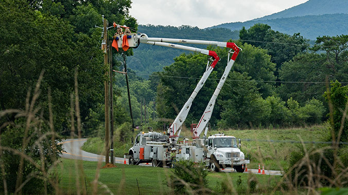 Georgia Power bucket trucks repairing poles in rural Georgia
