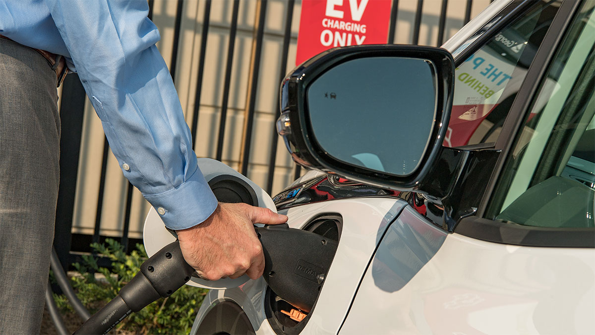 Man charging electric vehicle